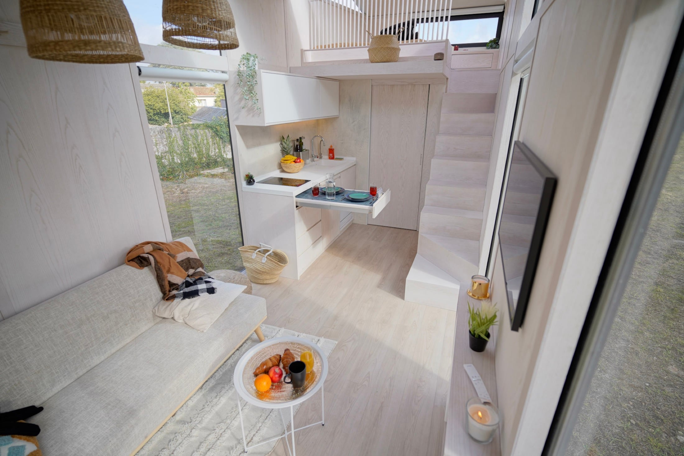 Intérieur d'une Tiny House Hoummi : séjour, cuisine et mezzanine sous verrière