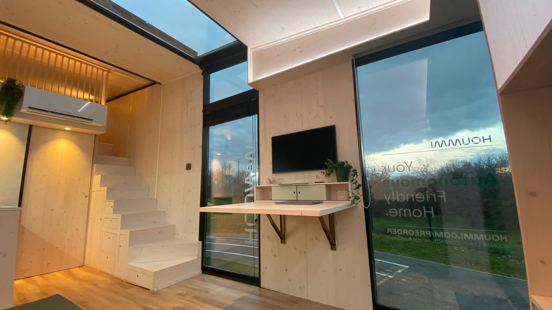Séjour d'un module Hoummi avec escalier-rangements, bureau escamotable et climatisation réversible