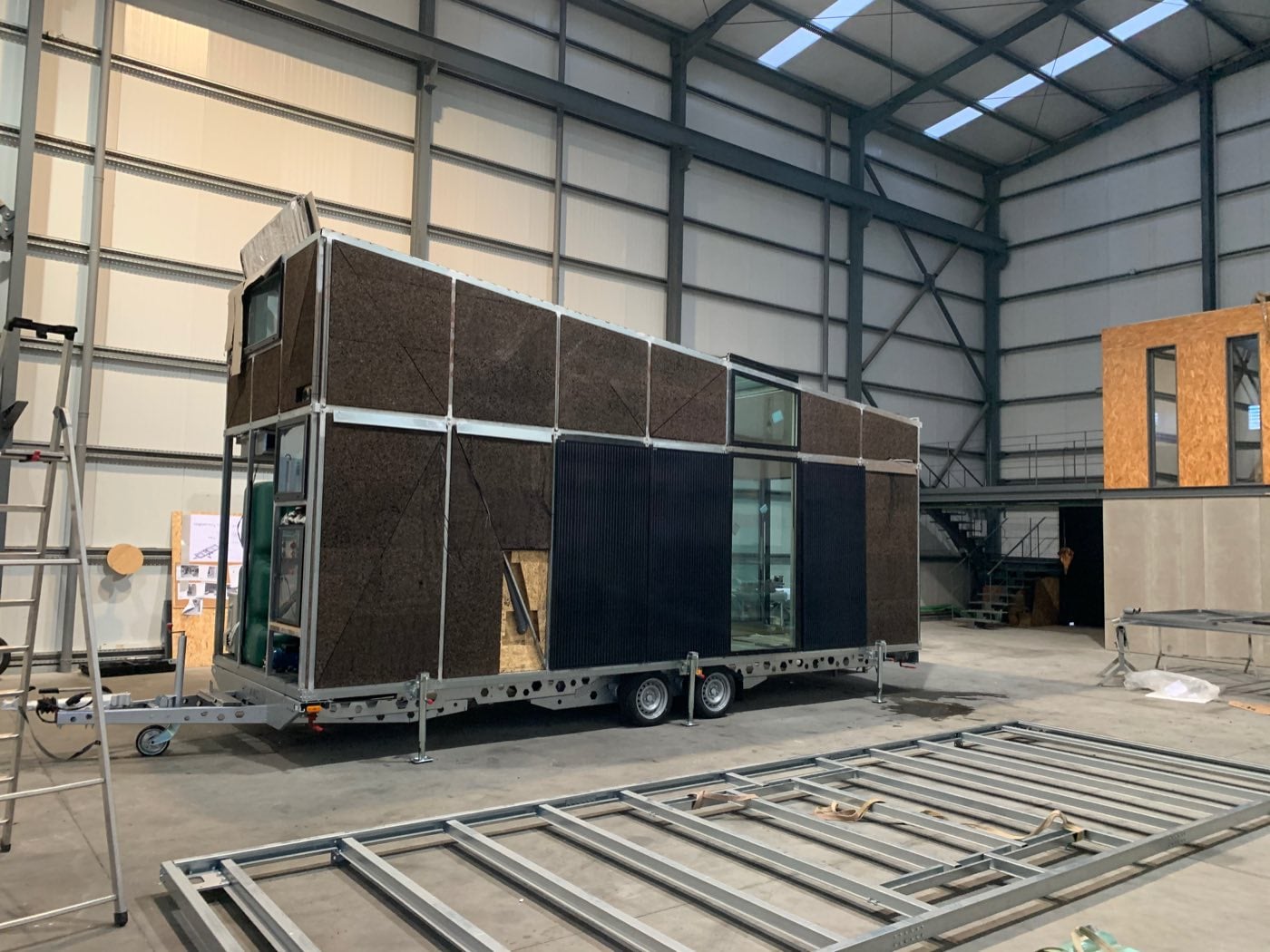 Module bardé bois posé sur sa remorque à l'intérieur de la halle de production