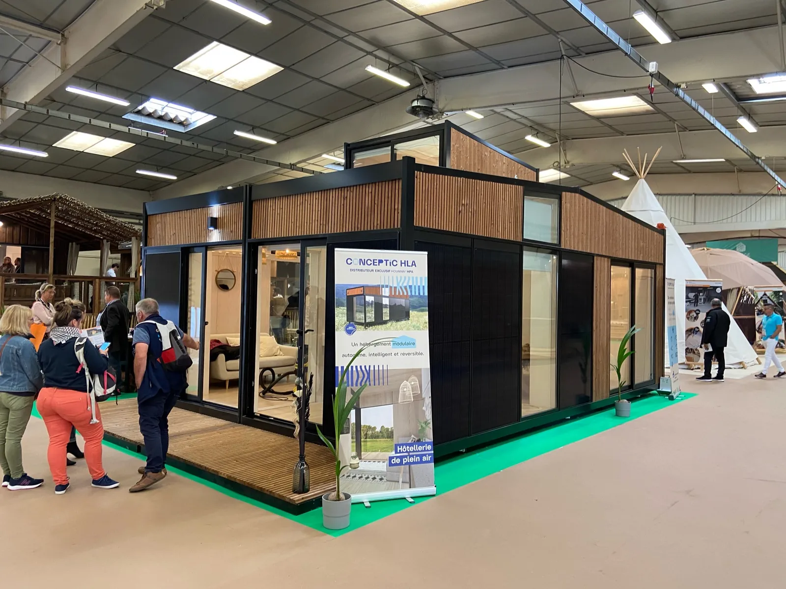 Module Hoummi exposé dans le hall d'un salon, visiteurs devant la façade