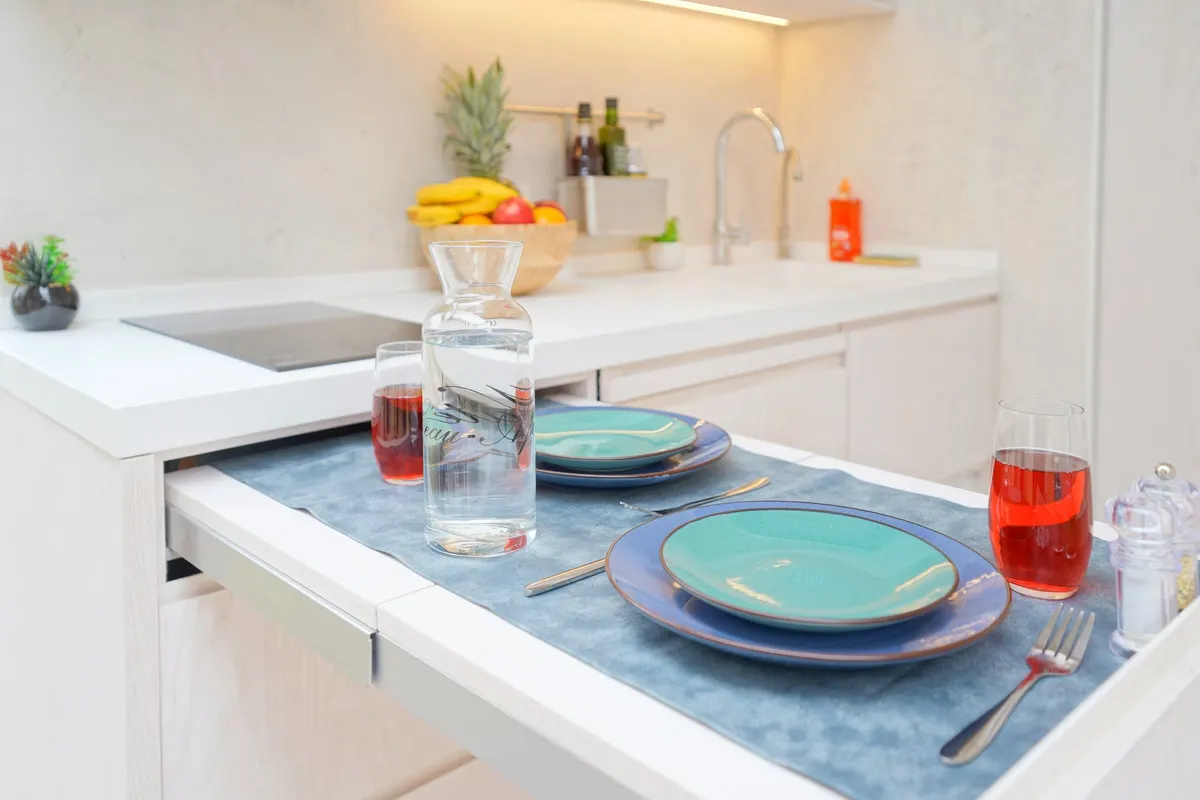 Cuisine d'un module Hoummi avec table escamotable dressée pour deux