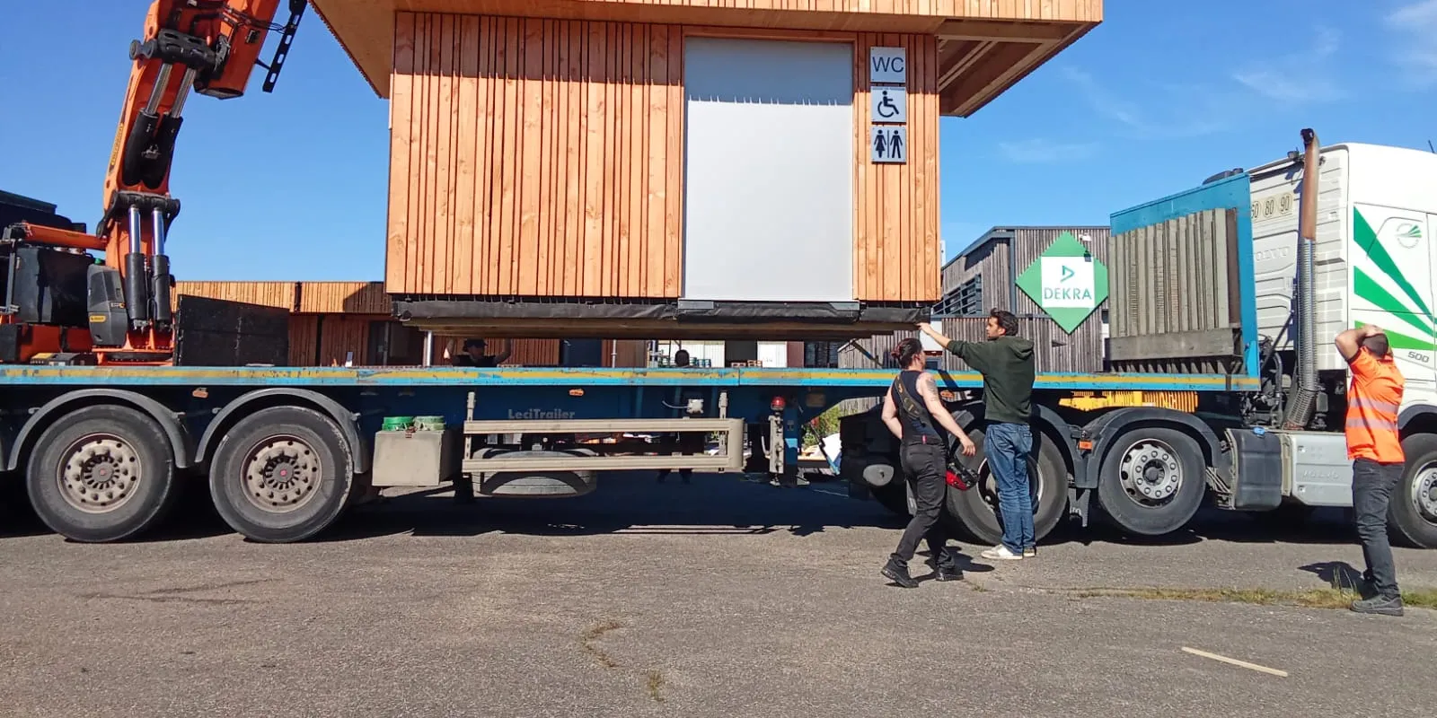 Module Hoummi fini, bardé bois, levé à la grue sur un camion dans la cour de l'atelier de Munster